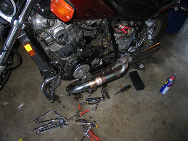 Left side exhaust system partially disassembled.  The exhaust system must be disassembled to attach the engine guards to the bike.