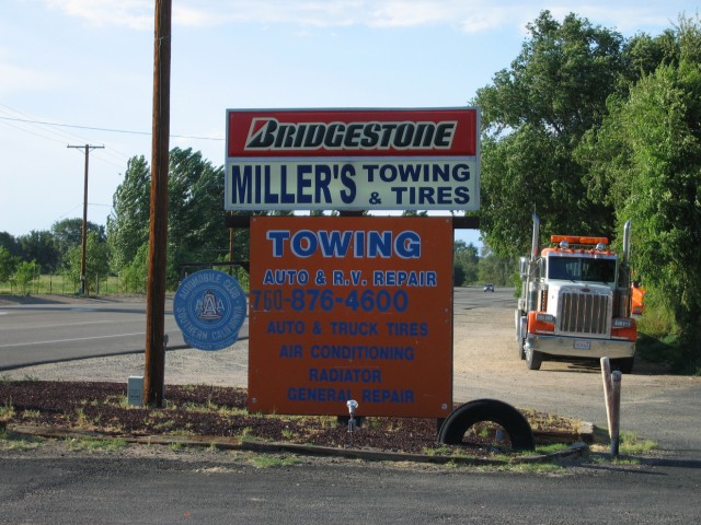 The sign for the repair shop that I stopped at.  Miller's Towing and Tires is the only place for miles and miles that can repair a car.